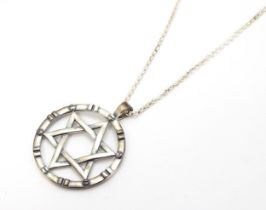 A silver pendant with Star of David detail, on silver chain. Pendant approx. 1 1/4" diameter