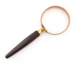 A 20thC German magnifying glass with turned wooden handle, the copper surround marked Eschenbach