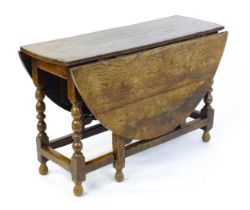 An early 18thC oak drop leaf table of large proportions, the table having two demi lune leaves and