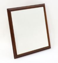 A late 20thC teak mirror with a moulded frame. 33" wide x 34" high. Please Note - we do not make