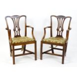 A pair of late 18thC fruitwood elbow chairs with Chippendale back splats, swept arms, drop in