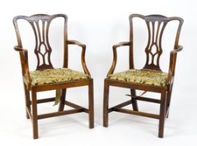 A pair of late 18thC fruitwood elbow chairs with Chippendale back splats, swept arms, drop in