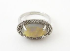 A silver ring set with opal cabochon. Ring size approx. P Please Note - we do not make reference