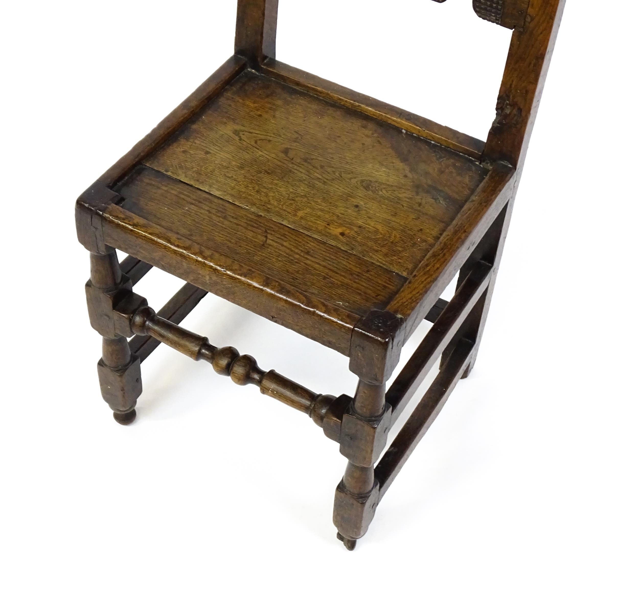 A 17thC oak peg jointed hall chair / back stool with a carved and scrolled top and mid rail raised - Image 6 of 7