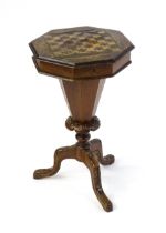 A 19thC trumpet shaped walnut sewing table with an octagonal hinged top inlaid with a games board,
