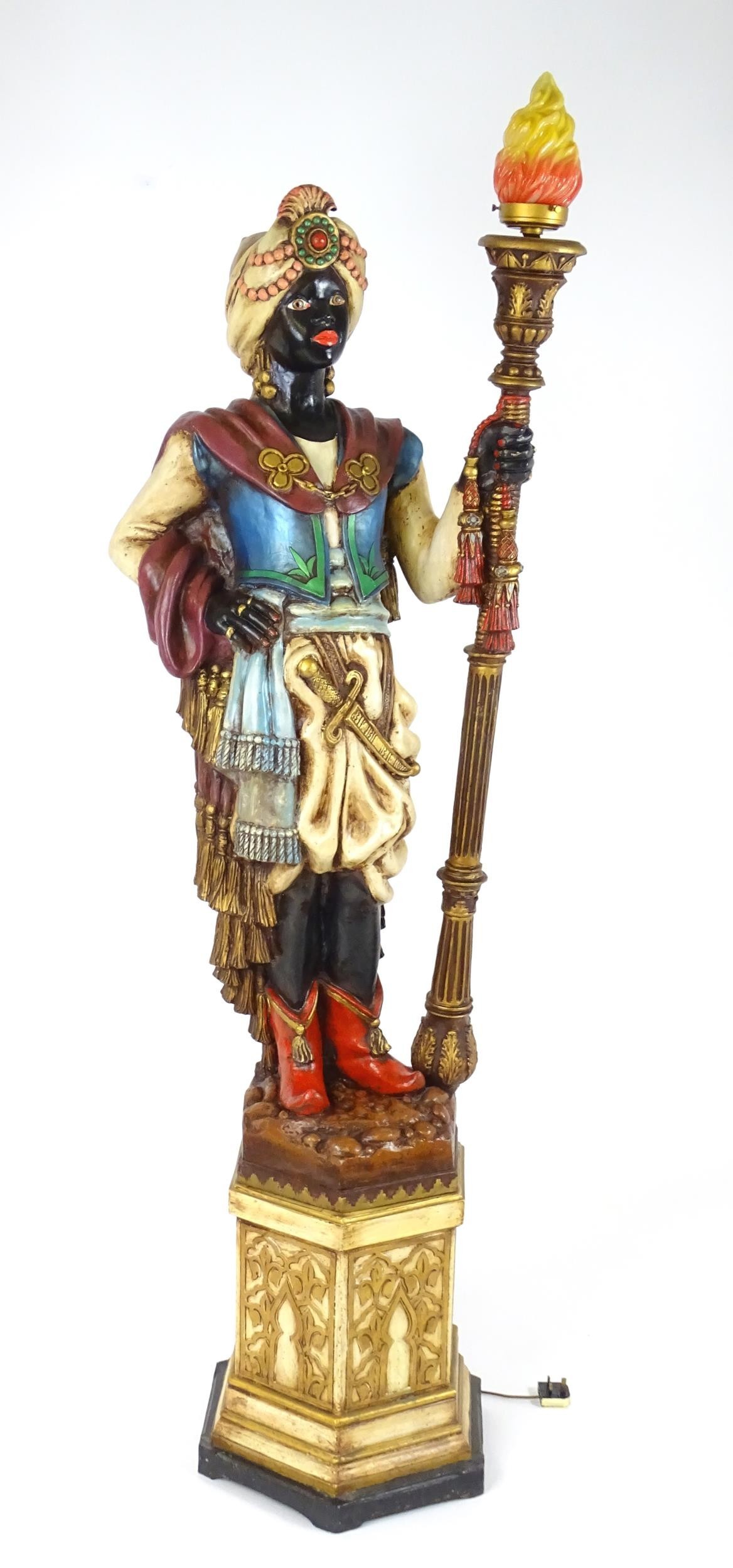 A mid 20thC blackamoor lamp, the lamp having a polychrome figural top grasping a torchiere, the - Image 2 of 14