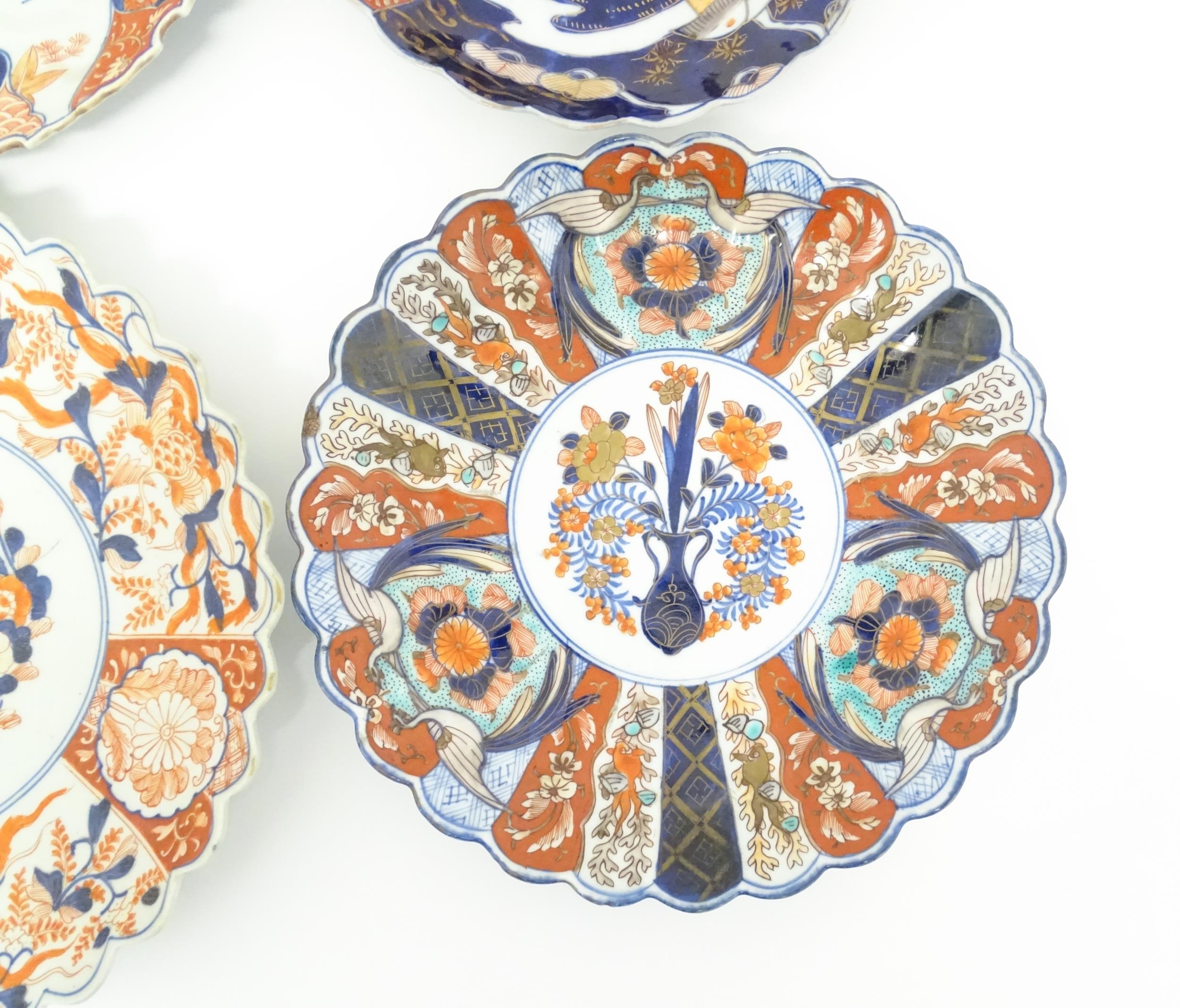 Four Japanese chargers with shaped edges decorated in the Imari palette with flowers, foliage and - Image 5 of 7