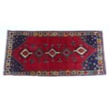 Carpet / Rug: A South West Persian Qashqai rug the red ground decorated with geometric motifs.