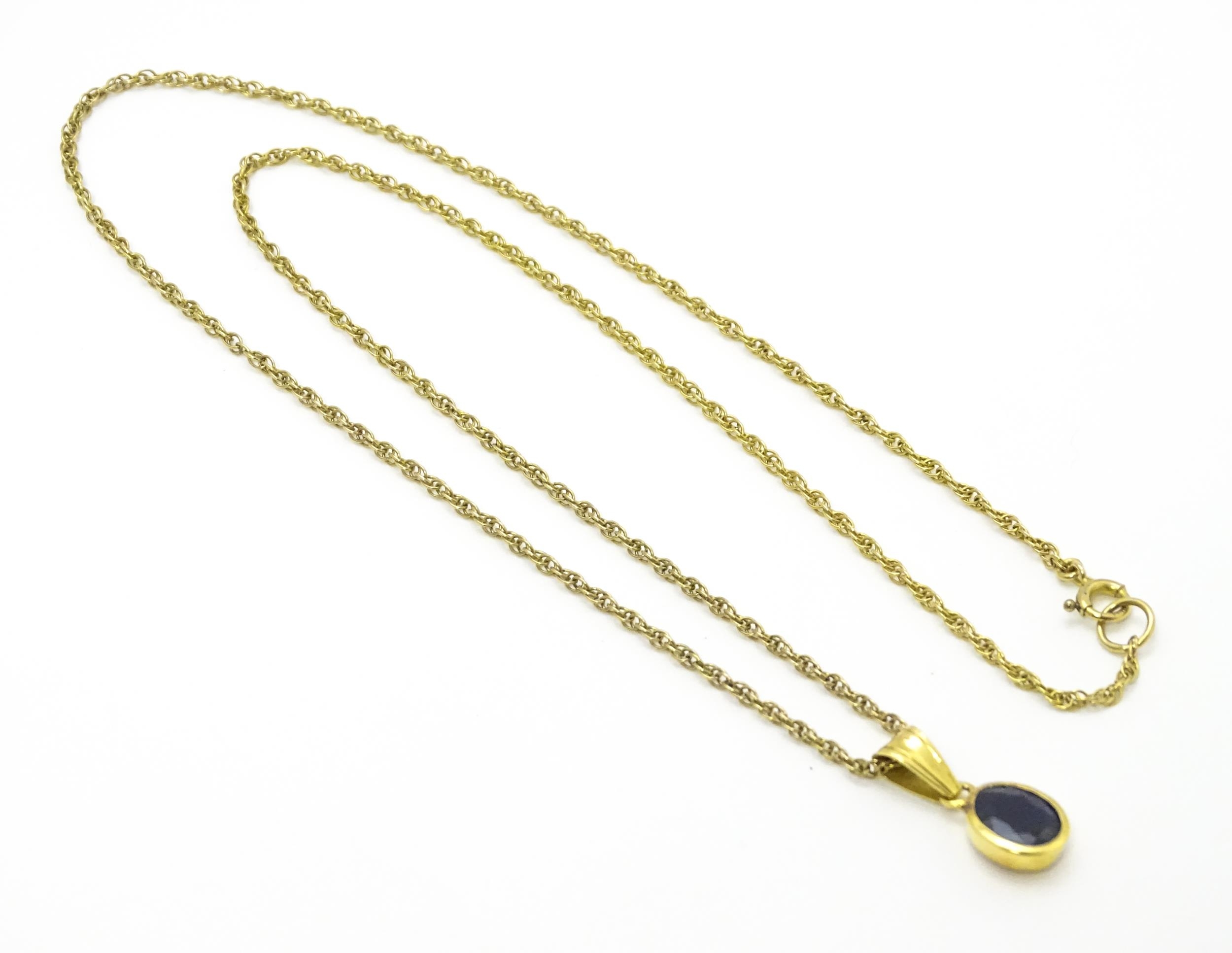 A yellow metal pendant set with central sapphire on a 9ct gold chain. Pendant approx. 1 3/4" long - Image 4 of 6