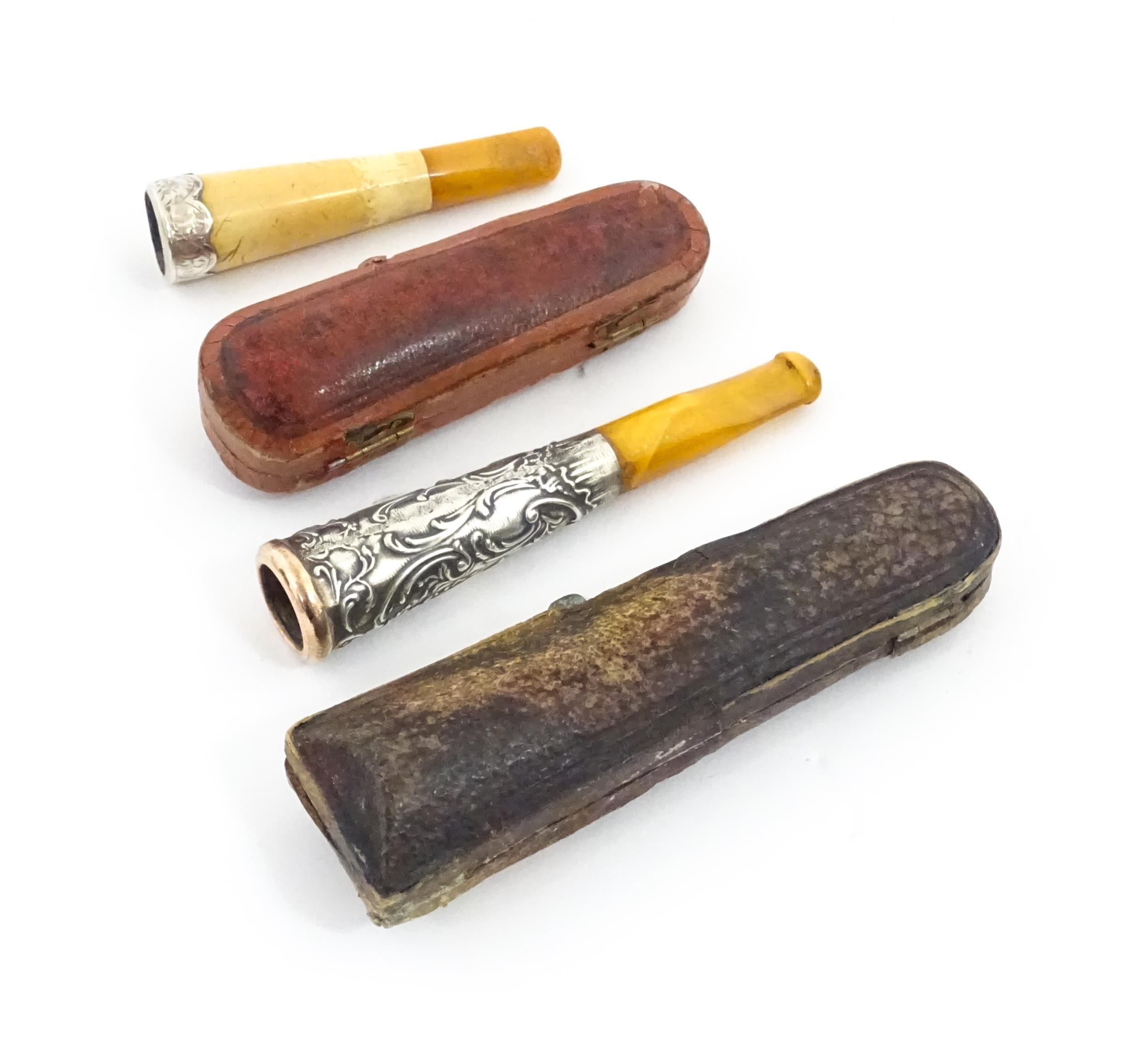 Two amber cheroot mouthpiece holders with white metal mounts, one with meerschaum detail. On - Image 3 of 8