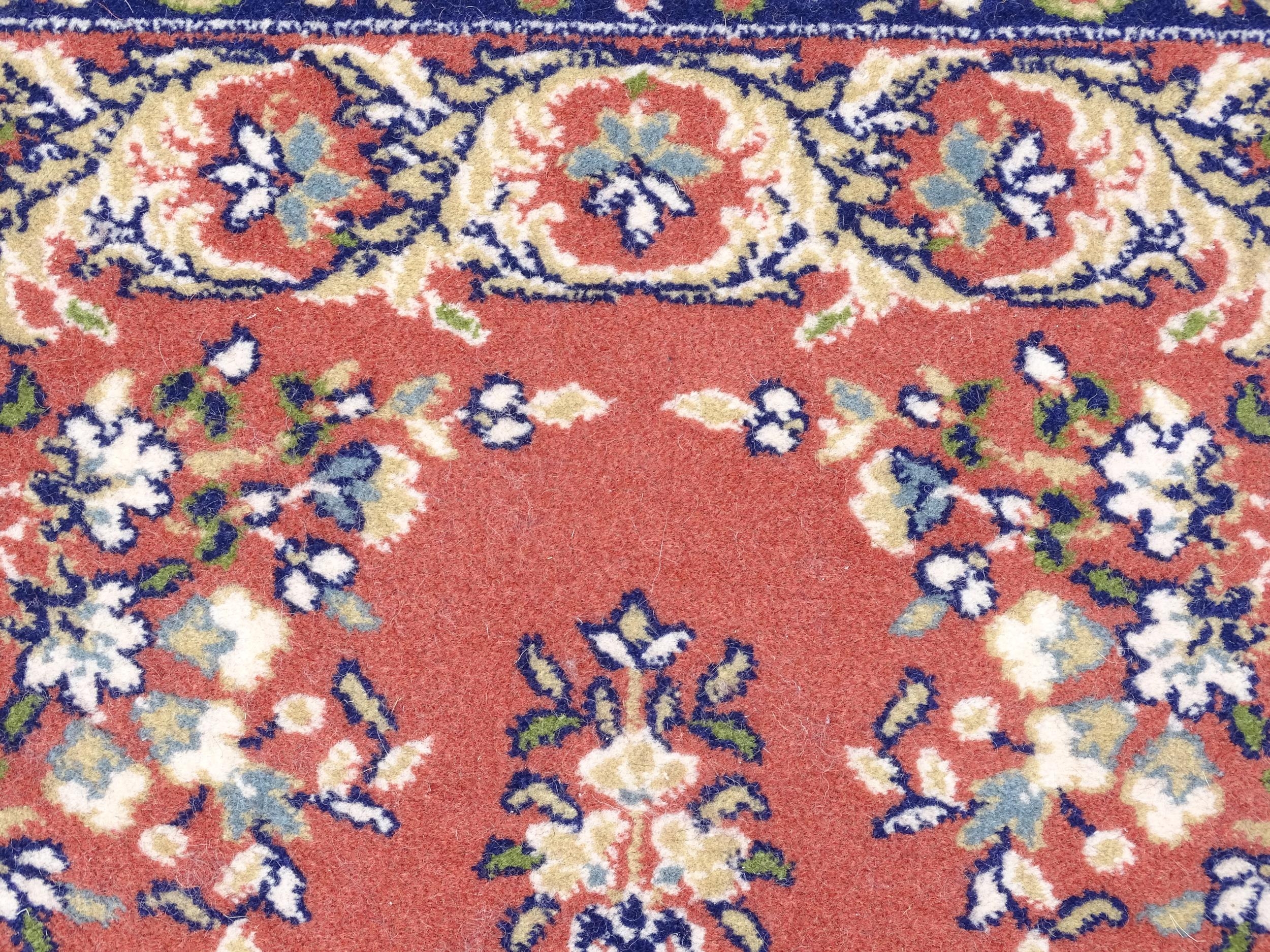 Carpet / Rug : A red ground rug with central floral motif, bordered by floral and foliate scroll - Image 5 of 7