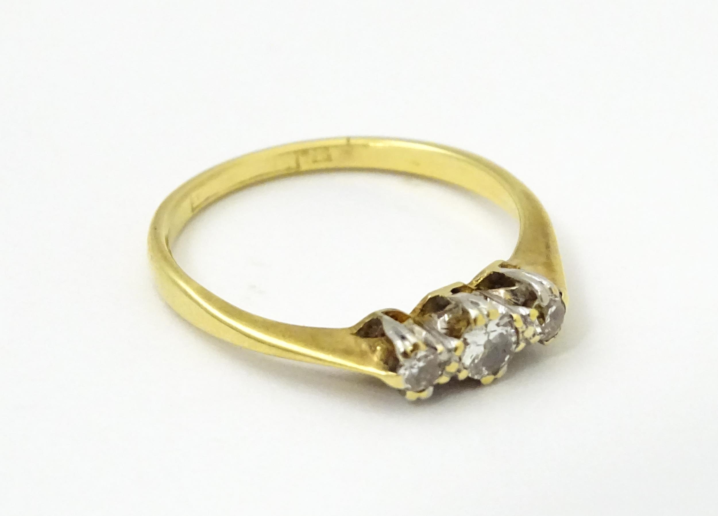 A gold ring set with a trio of diamonds in a platinum setting. Ring size approx. M Please Note - - Image 5 of 6