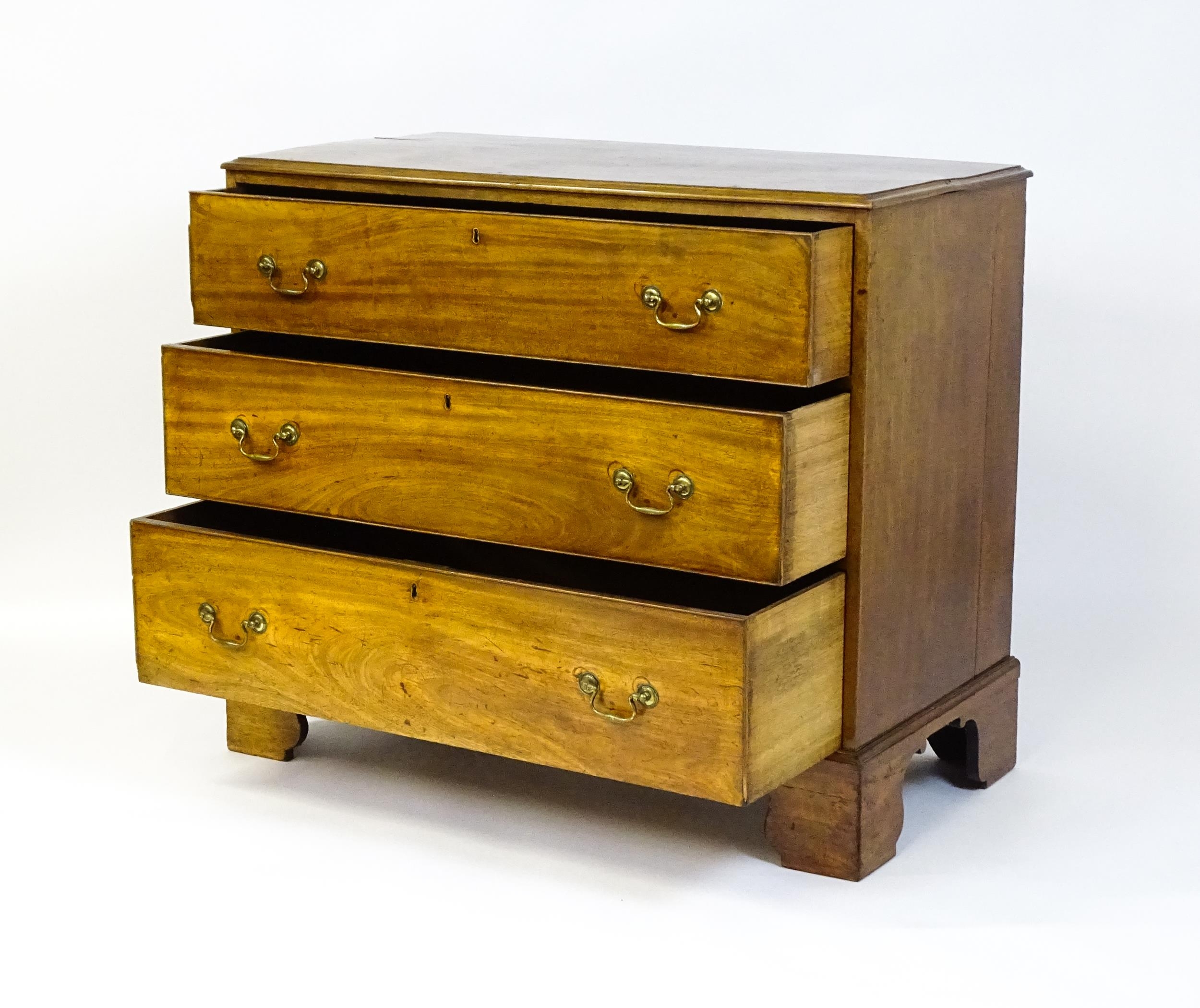 A late Georgian mahogany chest of drawers with a rectangular moulded top above three long drawers - Image 7 of 10