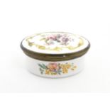 A 19thC snuff box of oval form with enamel decoration depicting flowers and foliage. Approx. 2 3/