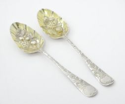 A pair of 18thC silver berry spoon with embossed fruit detail to bowls. Approx. 8" long (2) Please