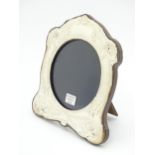 An easel back photograph frame with silver surround with Art Nouveau style decoration depicting