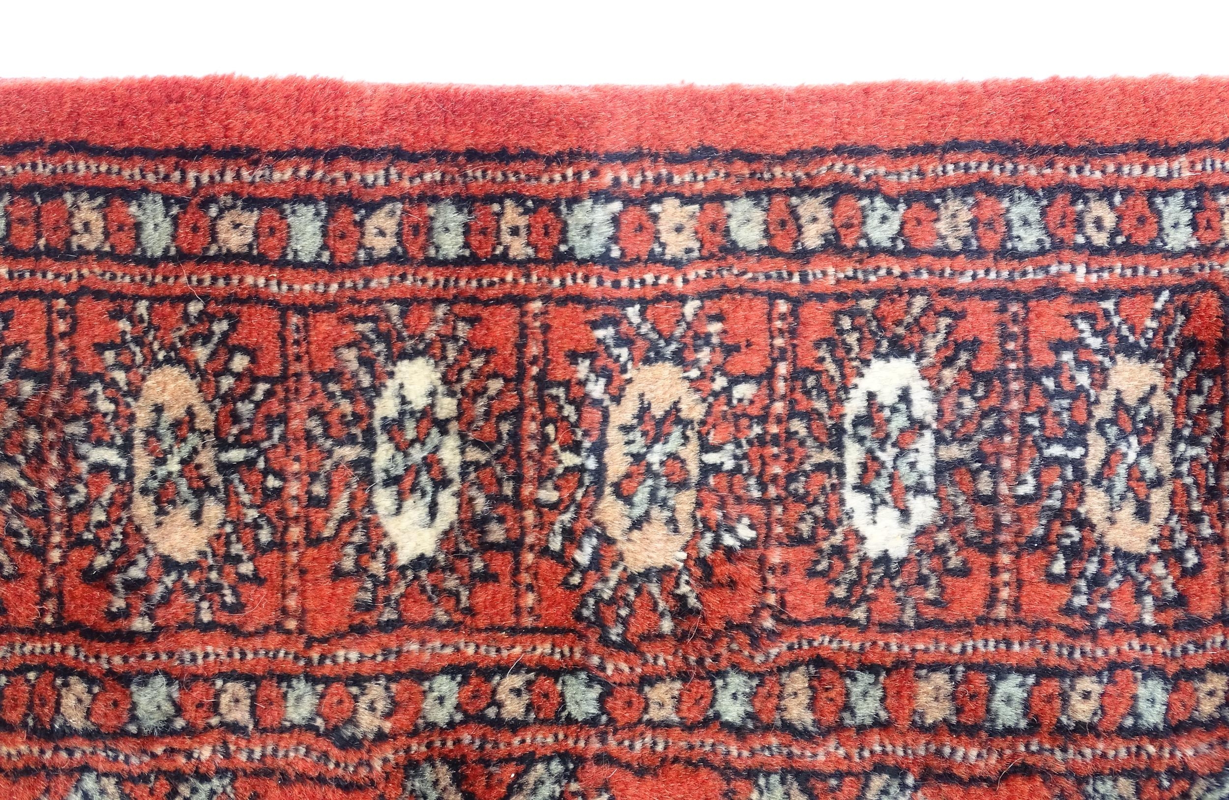 Carpet / Rug : A Pakistan wool red ground rug decorated with repeating geometric motifs with further - Image 6 of 8