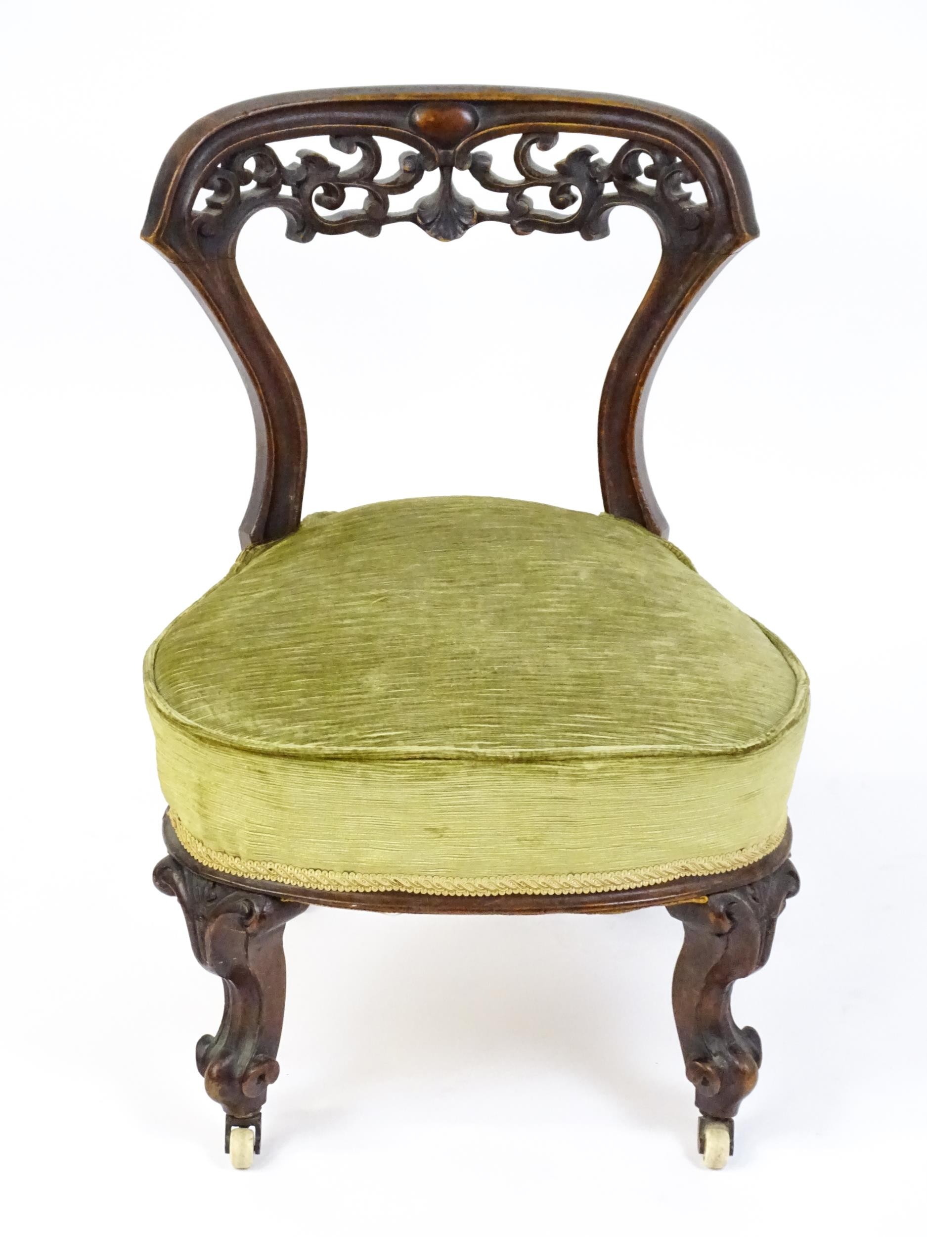 A mid / late 19thC mahogany nursing chair with a pierced, carved floral top rail above moulded - Image 4 of 6