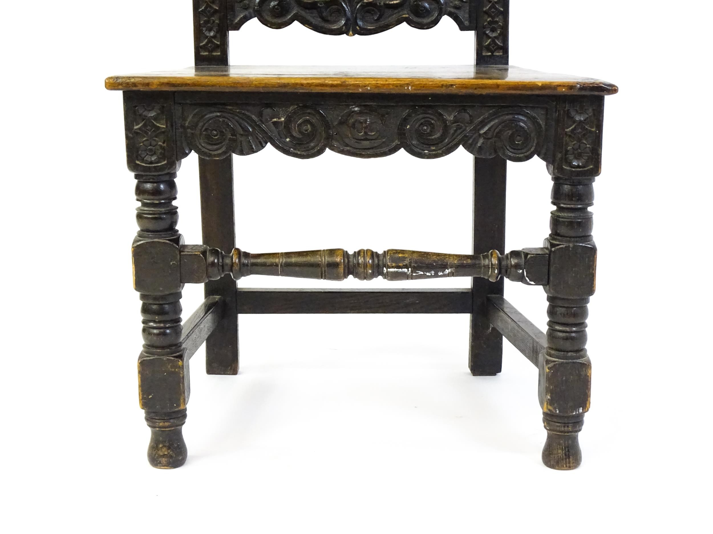 A 19thC carved oak side chair with floral carving, a planked seat and raised on block and turned - Image 4 of 6