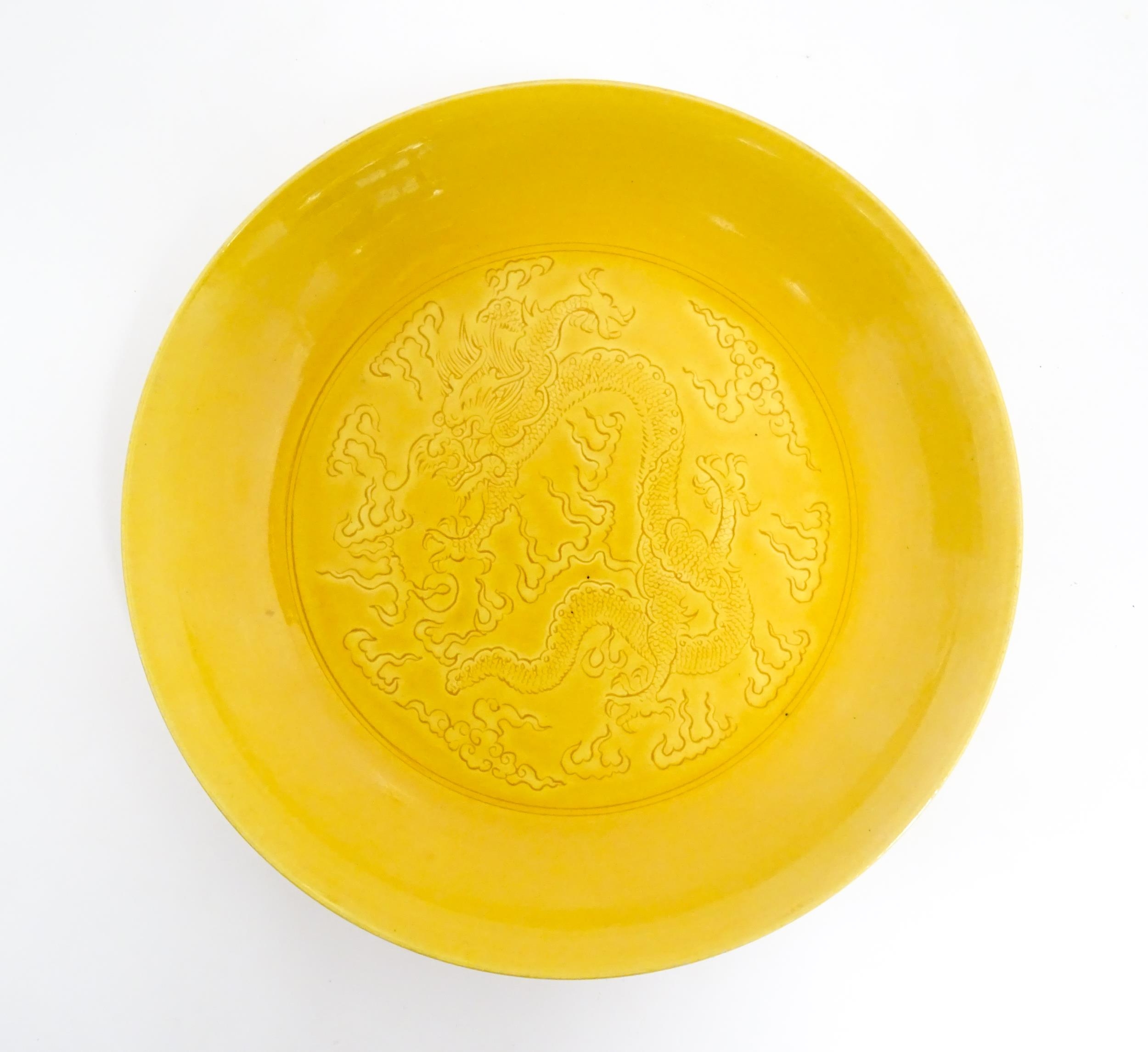 A Chinese dish with a yellow ground decorated with dragons amongst stylised clouds. Character - Image 3 of 4