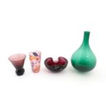 Four items of glassware to include a green bottle vase, an ashtray with controlled bubble detail,