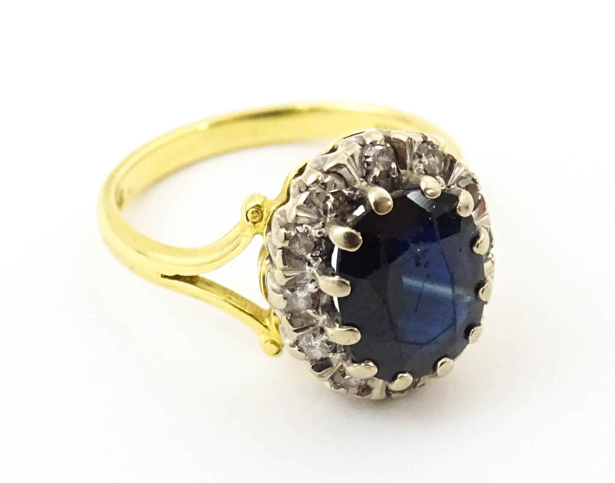 An 18ct gold ring set with central sapphire bordered by diamonds. Ring size approx. L 1/2 Please - Image 4 of 7