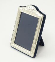 A silver fronted easel back photo frame with embossed decoration. Hallmarked Sheffield 1998, maker