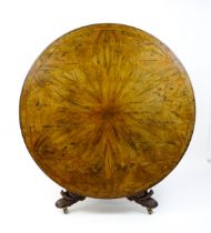 A 19thC dining table with an olive wood veneered circular top raised on a rosewood pedestal with