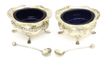 A pair of silver salts with blue glass liners, hallmarked Birmingham 1908, maker John Nowill & Sons.
