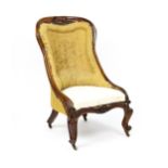 A 19thC rosewood nursing chair with a moulded frame and carved cresting rail raised on carved