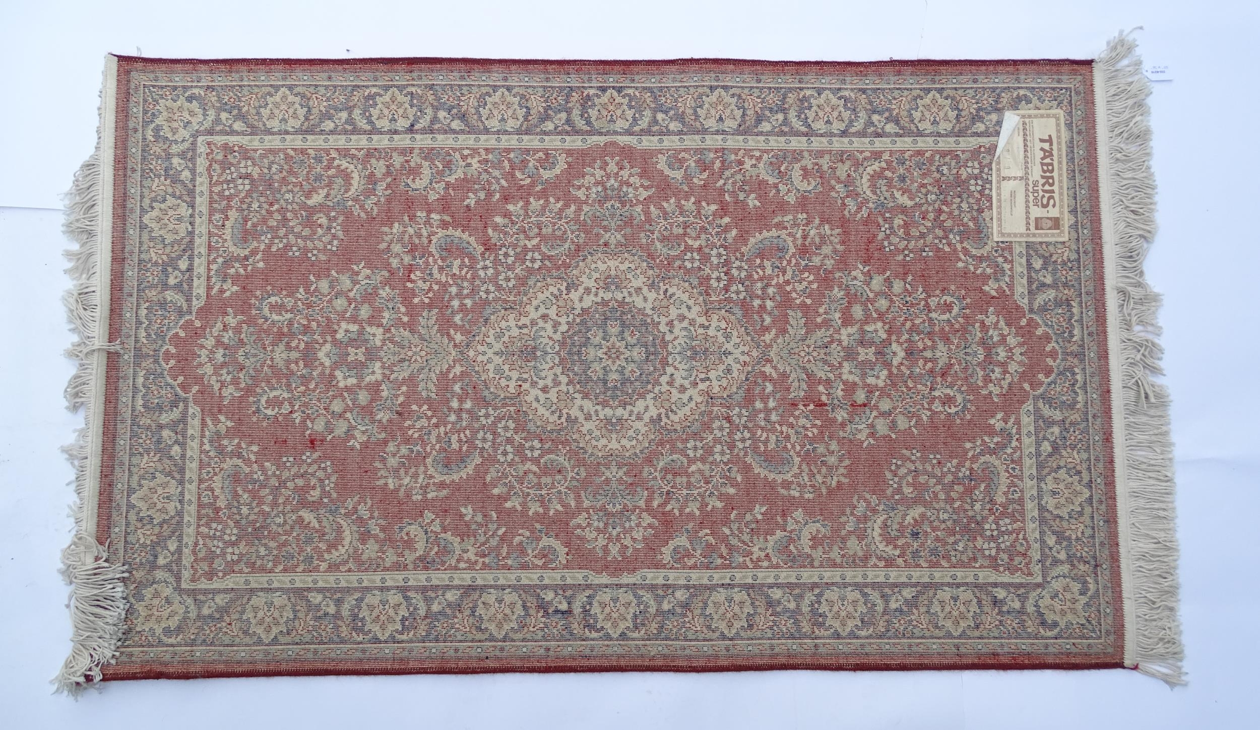 Carpet / Rug : A red ground rug with central cream and blue vignette, decorated with floral and - Image 2 of 6