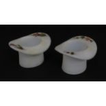 A pair of milk glass match holders / vesta keeps formed as top hats with hand painted floral detail.