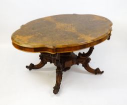 A 19thC burr walnut centre table with a moulded top above four acanthus carved supports, a large