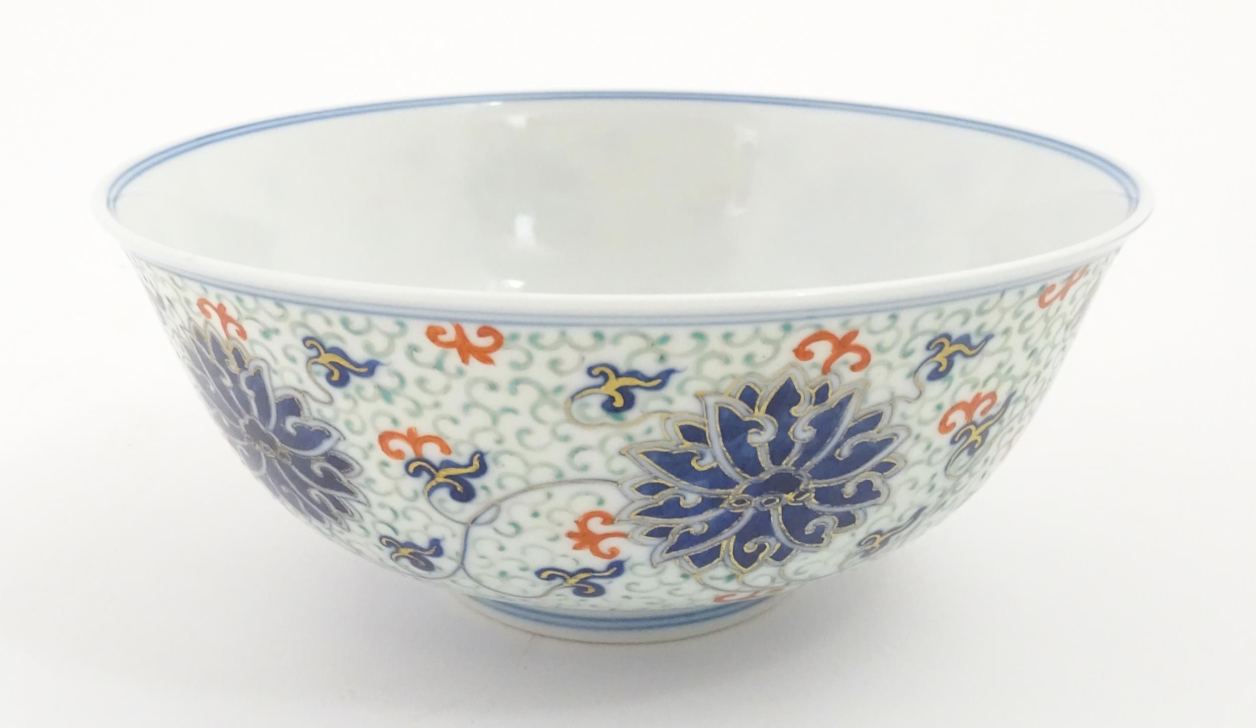 A Chinese bowl decorated with scrolling floral and foliate detail. Character marks under. Approx. 3"