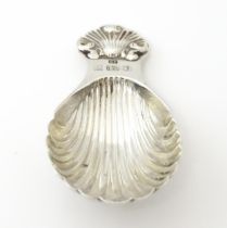 A silver caddy spoon with scallop shell detail, hallmarked Birmingham 1983 maker Douglas Pell