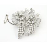 A diamond double clip brooch, the clips with flower and bow detail set with a profusion of