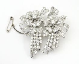 A diamond double clip brooch, the clips with flower and bow detail set with a profusion of