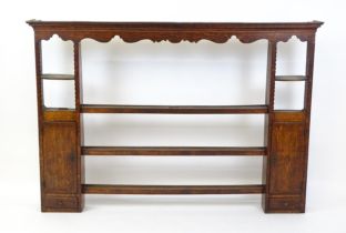 An 18thC oak plate rack / set of wall shelves with a moulded cornice above three central shelves