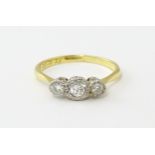 An 18ct gold ring with three platinum set diamonds. Ring size approx. O Please Note - we do not make