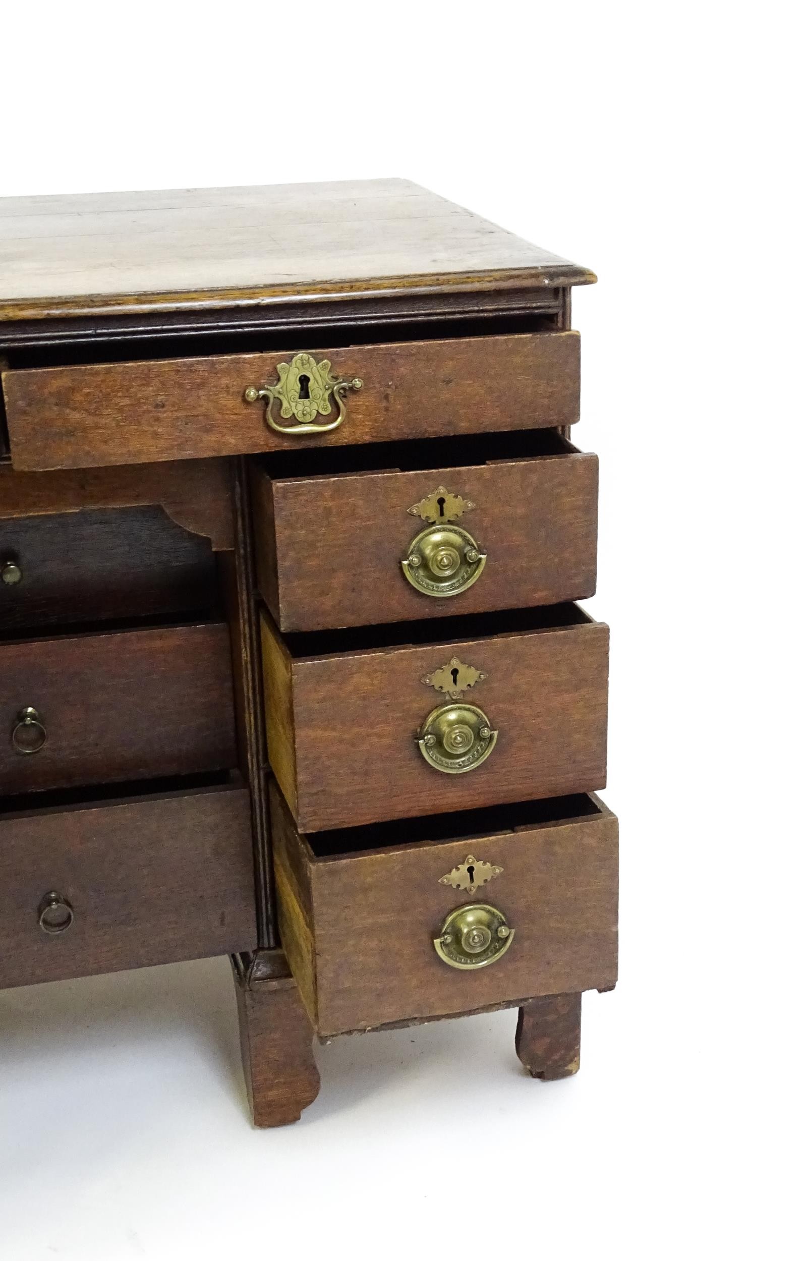An early / mid 18thC oak kneehole desk with a moulded top above two short drawers and two banks of - Image 3 of 10