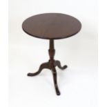 A 19thC mahogany tripod table with a turned pedestal above three cabriole legs. 27" high x 23" in