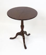 A 19thC mahogany tripod table with a turned pedestal above three cabriole legs. 27" high x 23" in