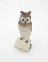 A Nymphenburg model of an owl perched upon a book with the motto In Arte Voluptas. Marked under