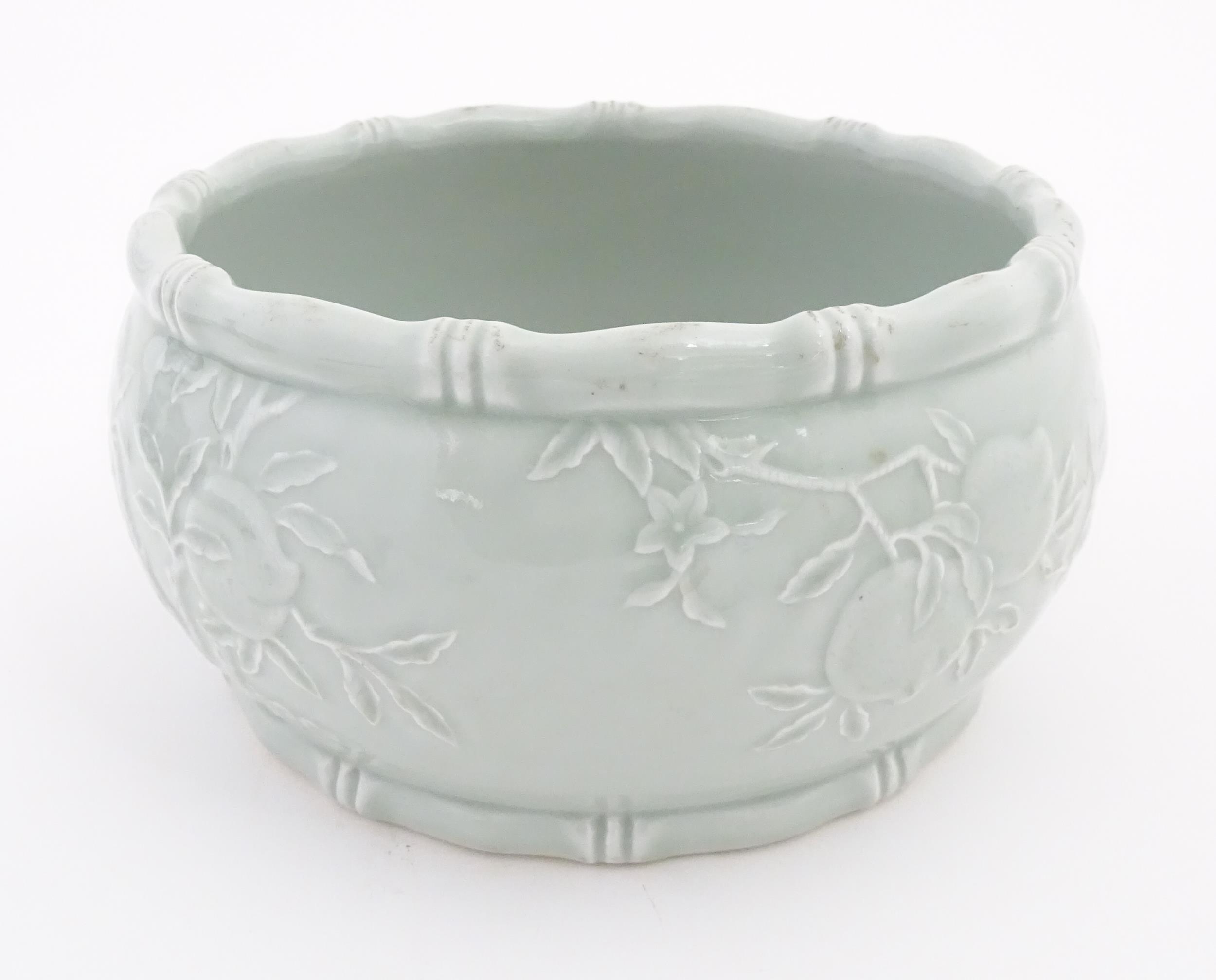 A Chinese celadon planter decorated in relief with peaches and bat detail, and stylised bamboo rims. - Image 3 of 7
