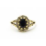 A 9ct gold ring set with central sapphire bordered by diamonds. Ring size approx. L 1/2 Please