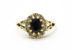 A 9ct gold ring set with central sapphire bordered by diamonds. Ring size approx. L 1/2 Please