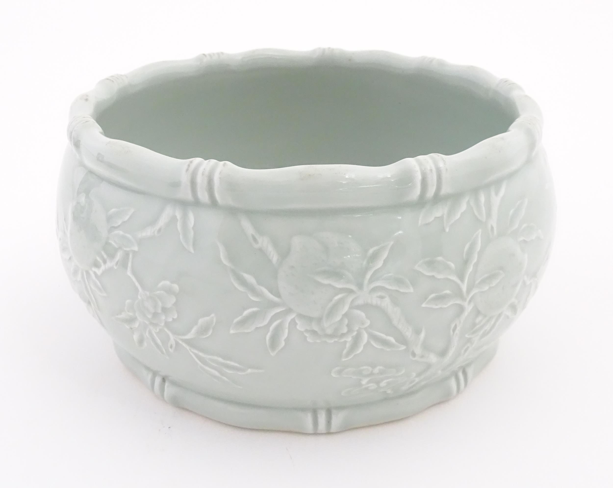 A Chinese celadon planter decorated in relief with peaches and bat detail, and stylised bamboo rims. - Image 4 of 7