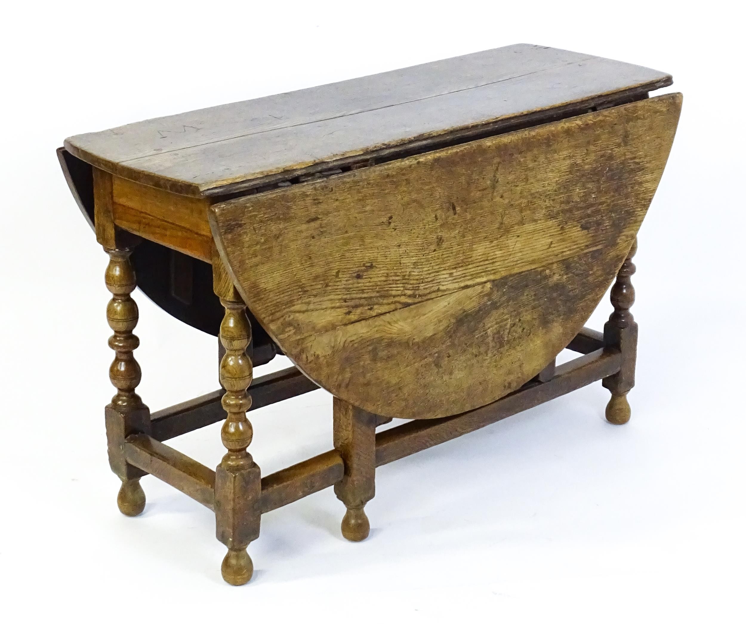 An early 18thC oak drop leaf table of large proportions, the table having two demi lune leaves and - Image 6 of 6