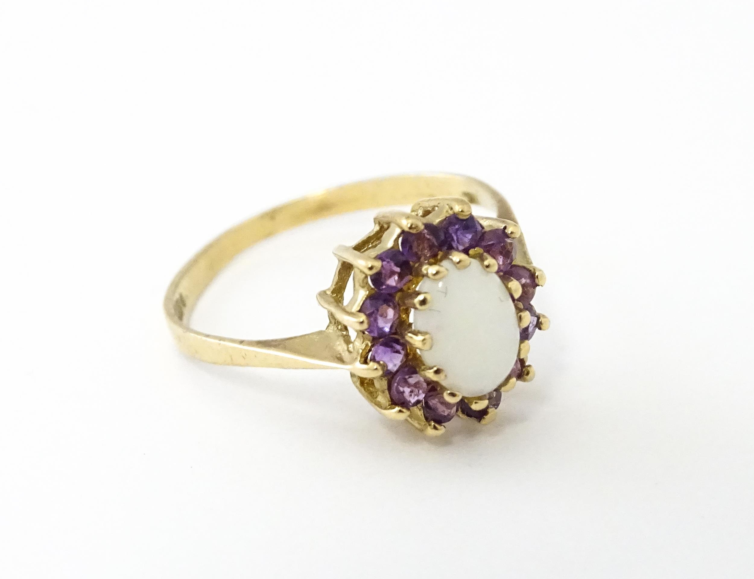 A 9ct gold ring set with central opal bordered by amethysts. Ring size approx. M Please Note - we do - Image 4 of 7