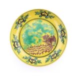 A small Chinese dish with a yellow ground decorated with a dragon, phoenix and flaming pearl.
